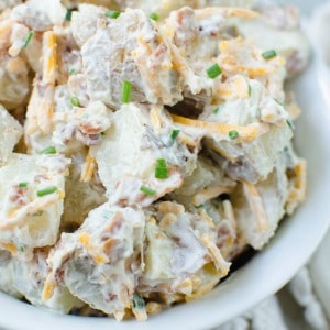 Baked Potato Salad - everything you love about baked potatoes in a cold potato salad! Potatoes tossed in sour cream, bacon, cheddar cheese, and chives. Perfect for summer barbecues!